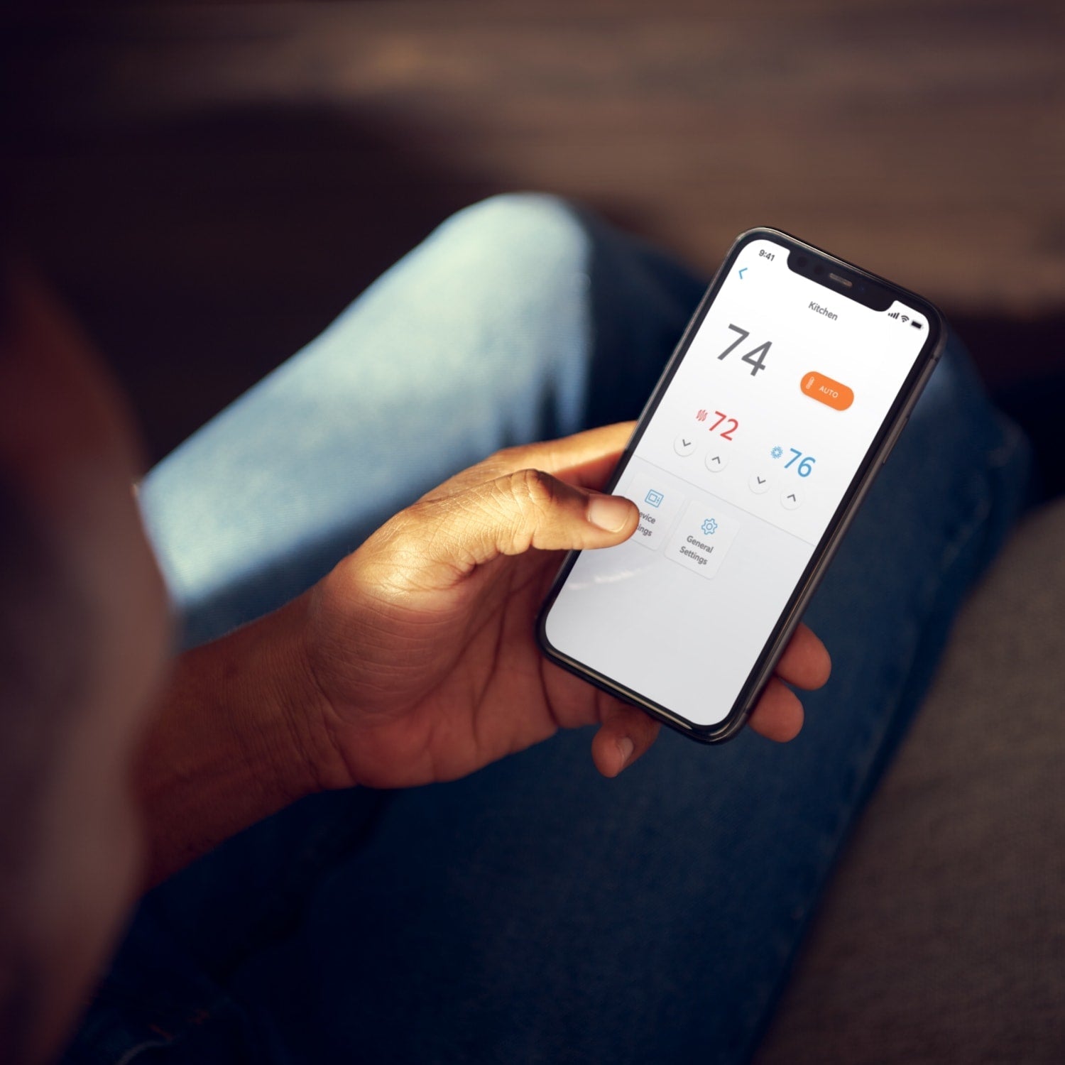 Amazon Smart Thermostat - Person using Ring App to adjust Amazon Smart Thermostat, with 74 degrees showing as current indoor temperature.