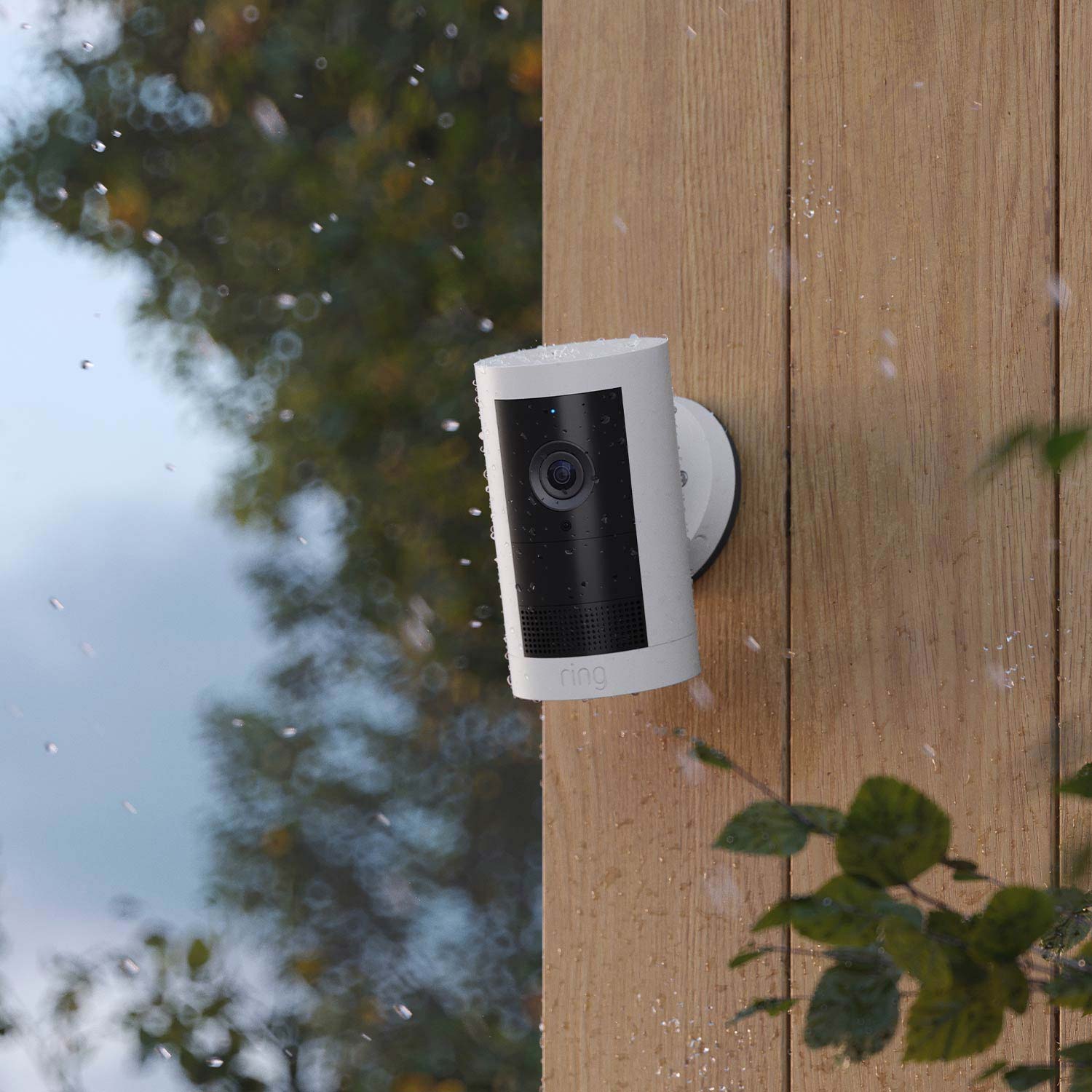 Outdoor Cam Plus (Featuring Retinal 2K)  - Battery:White Ring Outdoor Cam Plus on wood wall, covered in raindrops in rainy weather.