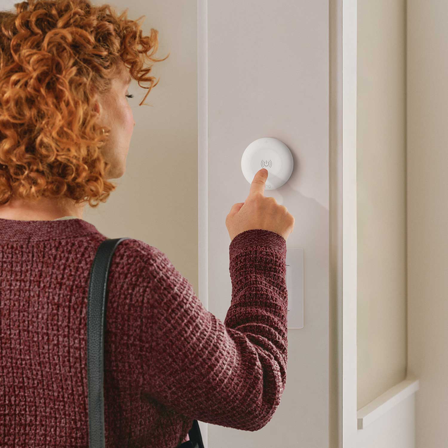 Smart Light Remote - Woman pressing Smart Light Remote  on wall.