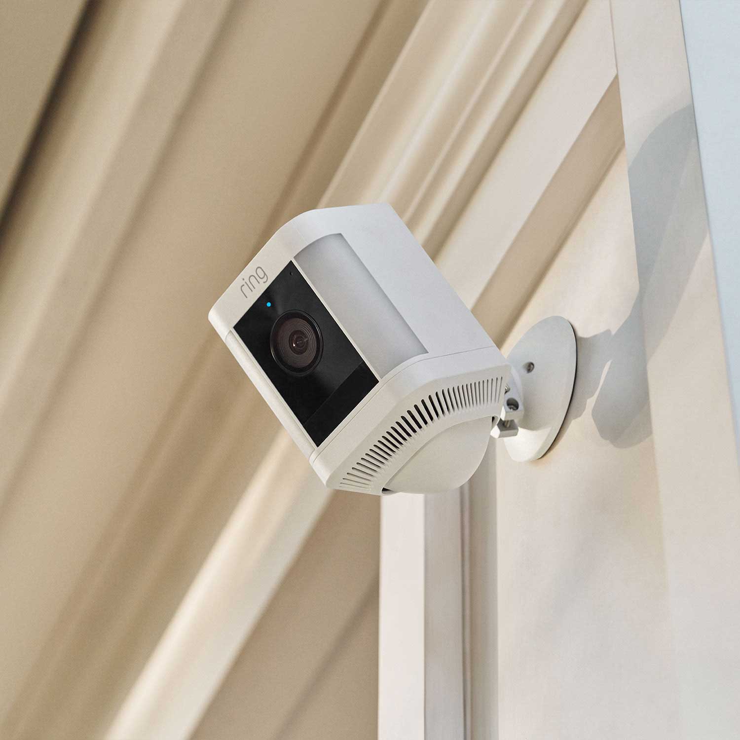 Front and Backyard Basic Kit (Outdoor Cam Plus Battery + Spotlight Cam Plus Battery) - A view from below of a white Ring Spotlight Cam Plus mounted to wood.