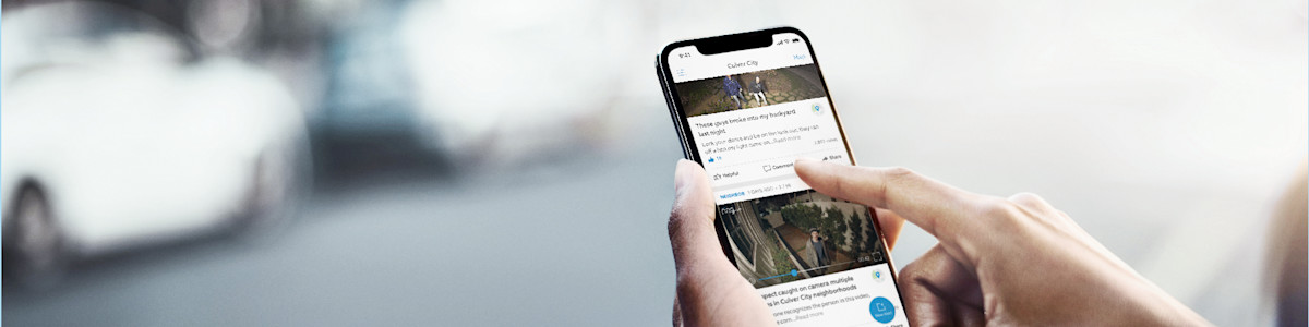 Image of a neighbor holding a smartphone displaying the Neighbors app feed interface.