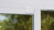 A white Ring Contact Sensor mounted on a door frame