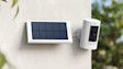 Ring security camera with solar panel mounted on white wall