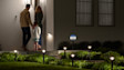 Illuminated garden path with landscape lighting with a Ring Video Doorbell and Solar Security Sign at night