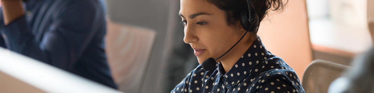 Customer service representative in polka dot blouse wearing headset